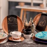 4 platos de caramica pintados junto a pinceles- espacio creativo