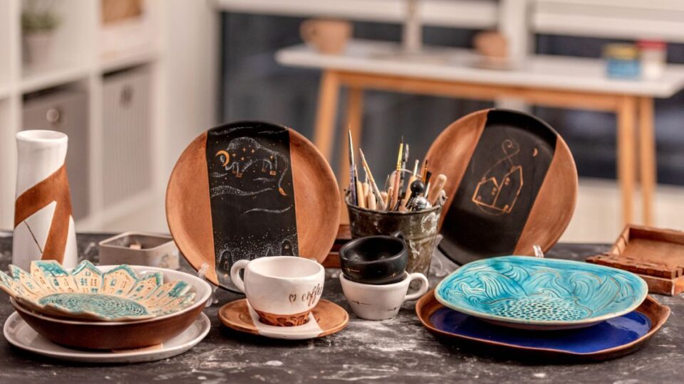 4 platos de caramica pintados junto a pinceles- espacio creativo