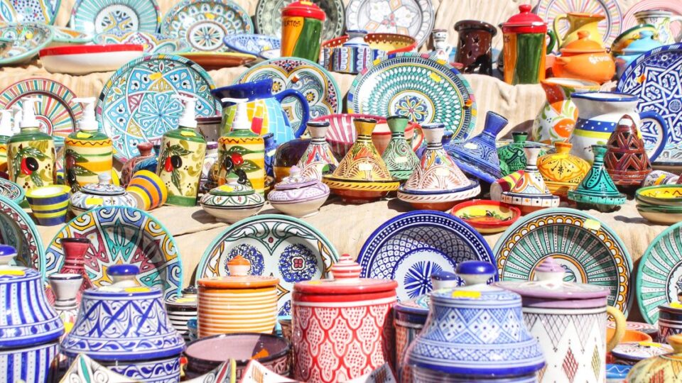 Colección de cerámica artesanal con platos, tajines y jarras pintados a mano en colores vivos