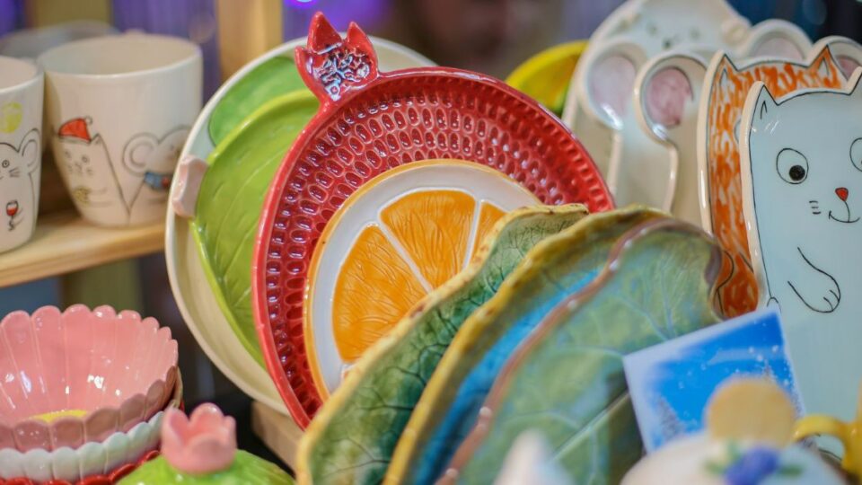 Platos y tazas de cerámica artesanal con disenos coloridos y formas creativas.