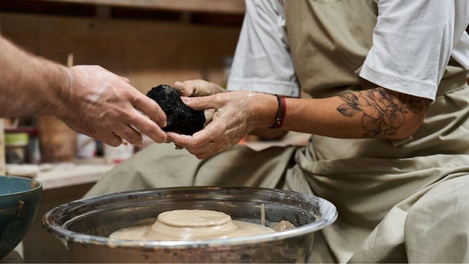 dos personas haciendo una figura de barro- espacio creativo